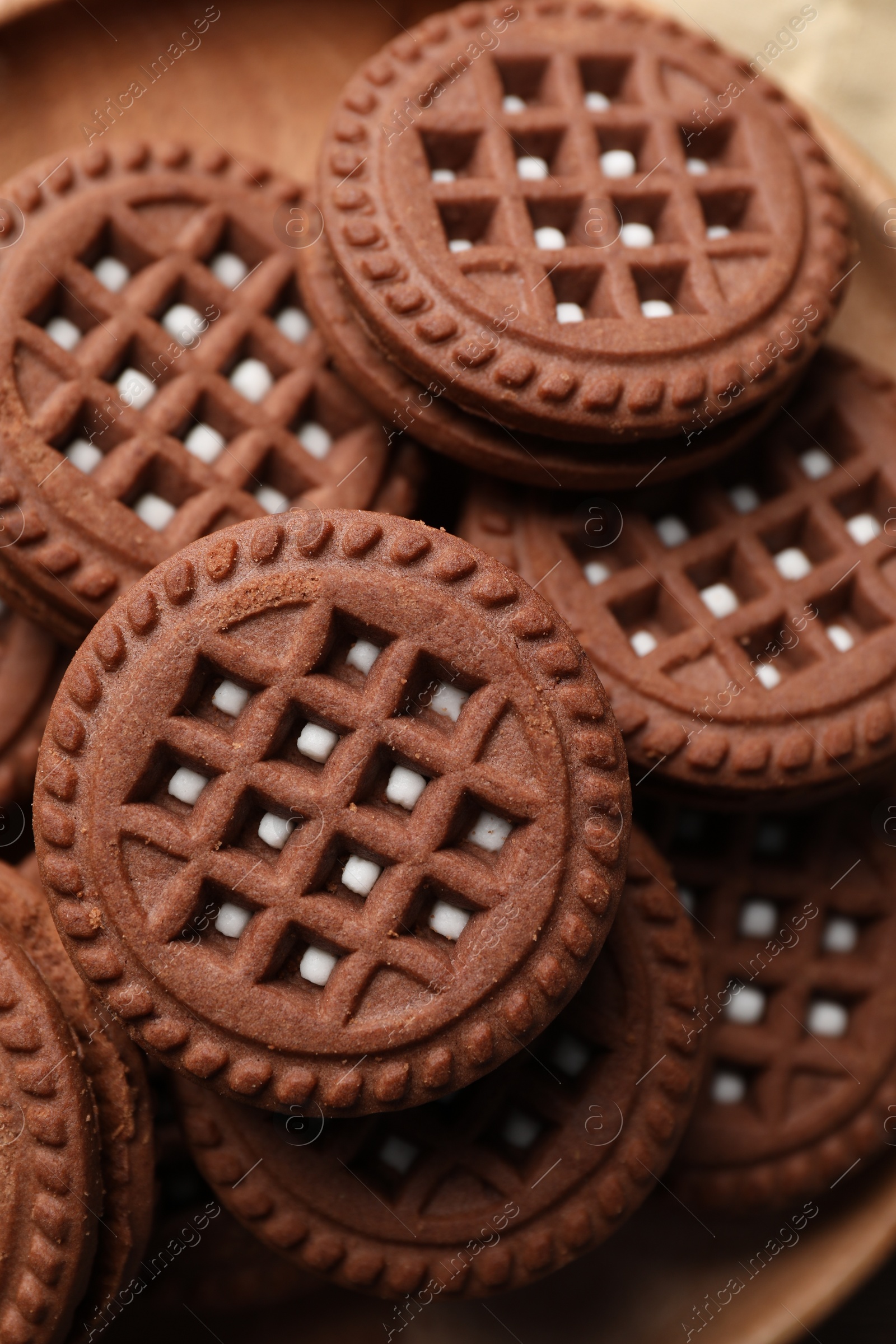 Photo of Tasty chocolate sandwich cookies with cream on plate, closeup