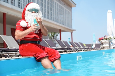 Authentic Santa Claus with cocktail near pool at resort