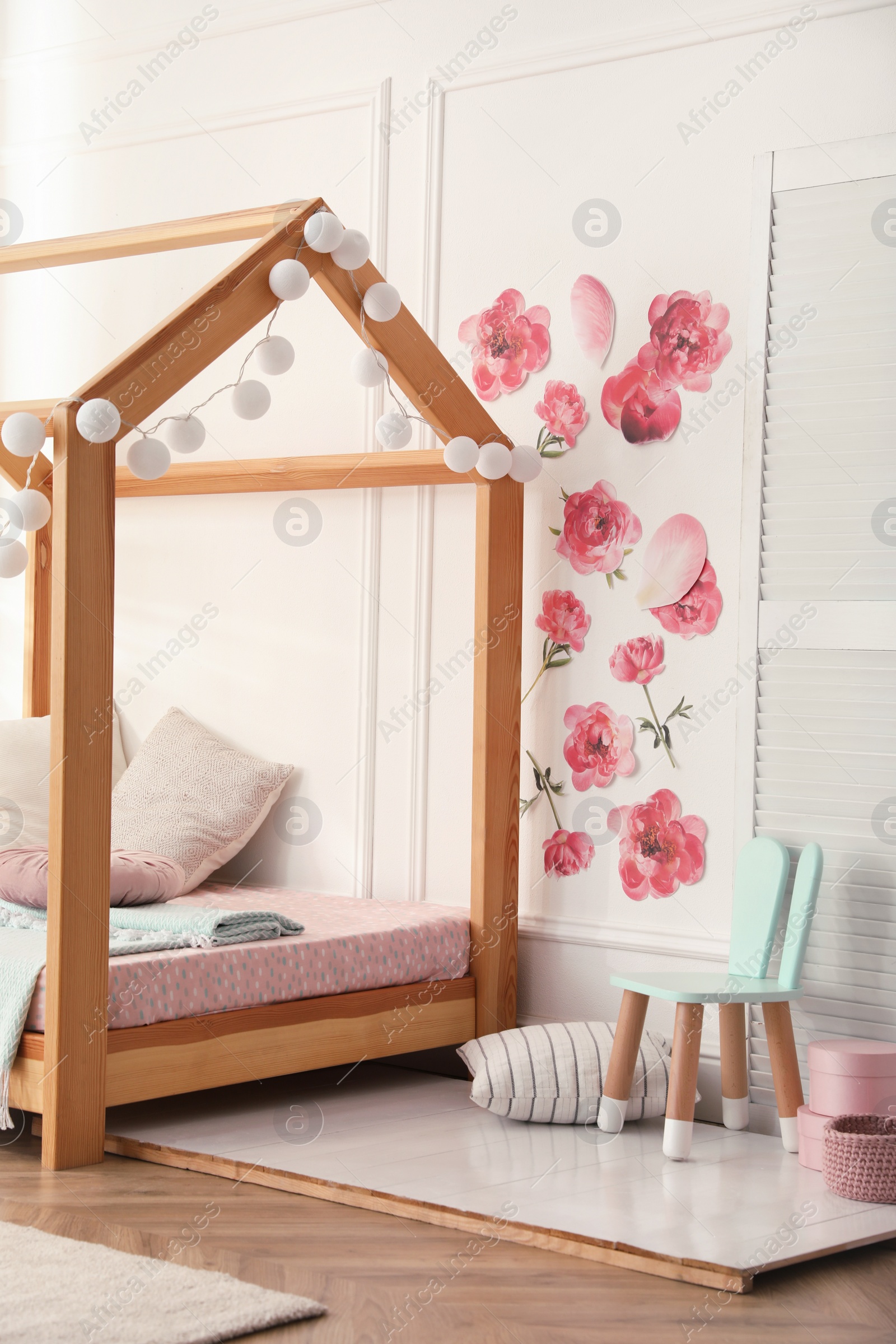 Photo of Stylish child room interior with wooden house bed