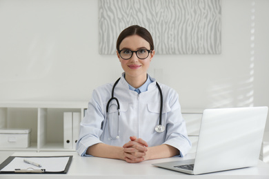 Photo of Portrait of young female doctor in white coat at workplace