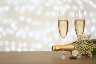 Photo of New year composition with champagne and space for text against blurred Christmas lights