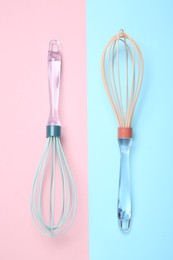 Photo of Two whisks on color background, top view