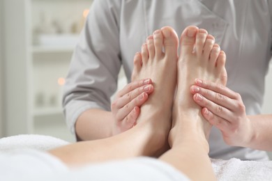Photo of Woman receiving feet massage in spa salon, closeup