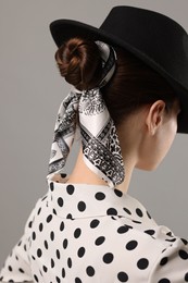 Photo of Woman with black hat and stylish bandana on light grey background