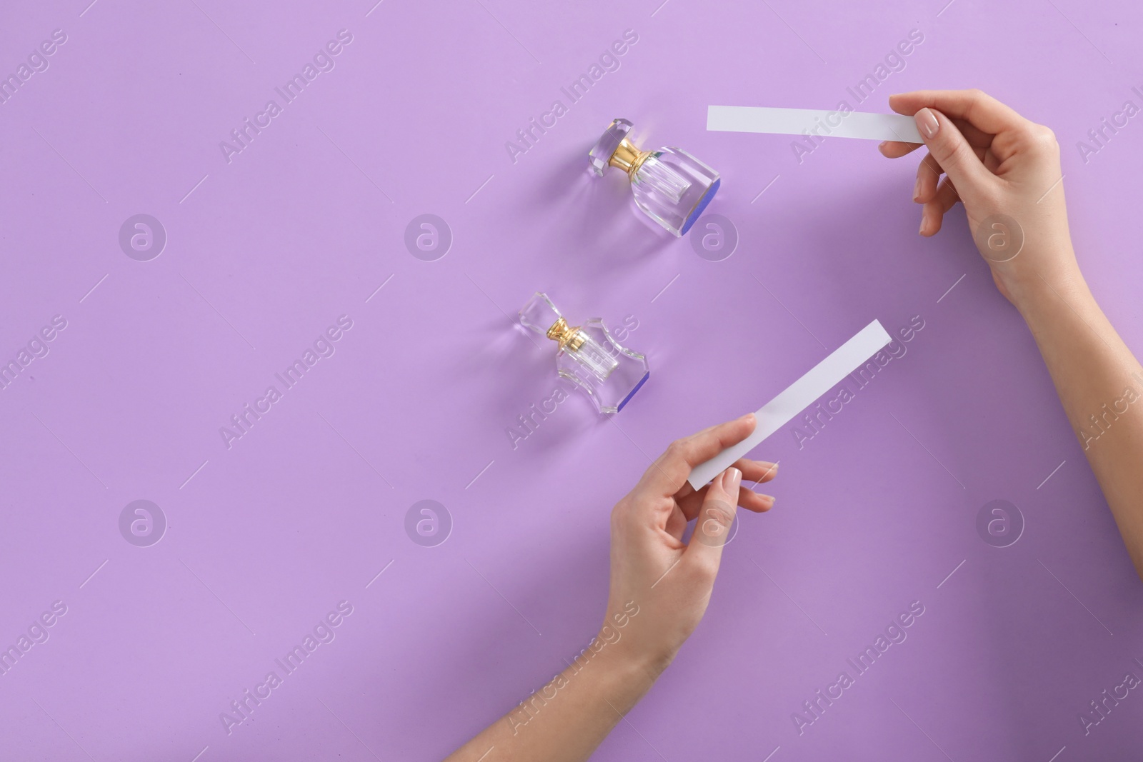 Photo of Woman with perfume blotters on violet background, top view. Space for text