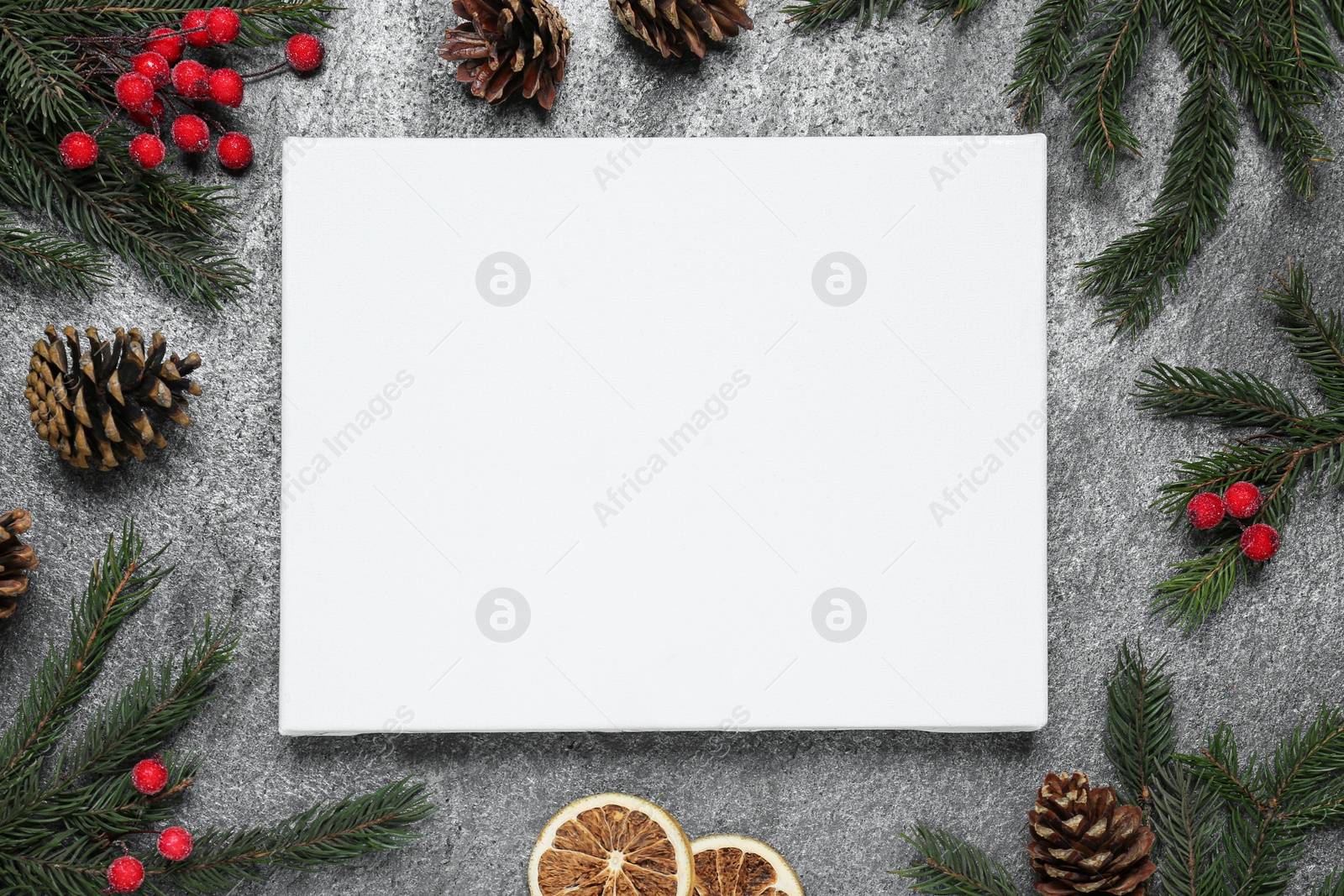 Photo of Blank canvas and Christmas decor on grey table, flat lay. Space for design