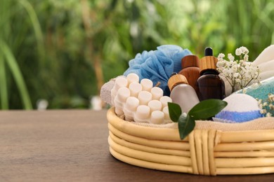 Photo of Spa gift set with different products on wooden table against blurred background. Space for text