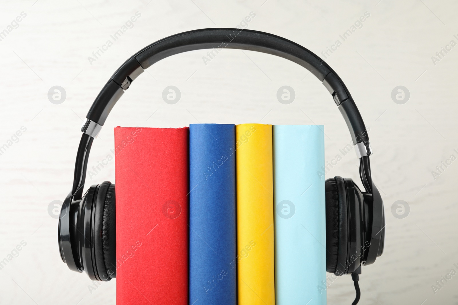 Photo of Books and modern headphones on white background, closeup