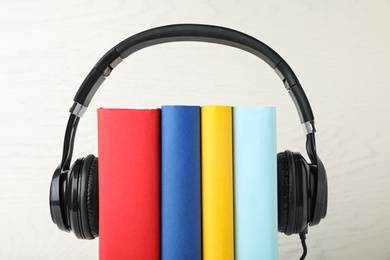 Books and modern headphones on white background, closeup