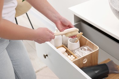 Photo of Bath accessories. Woman organizing personal care products indoors, closeup