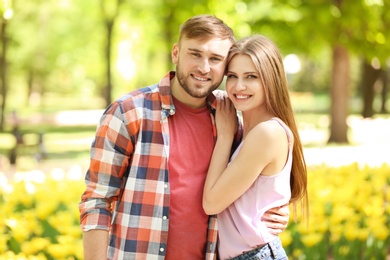 Happy young couple in green park on sunny spring day