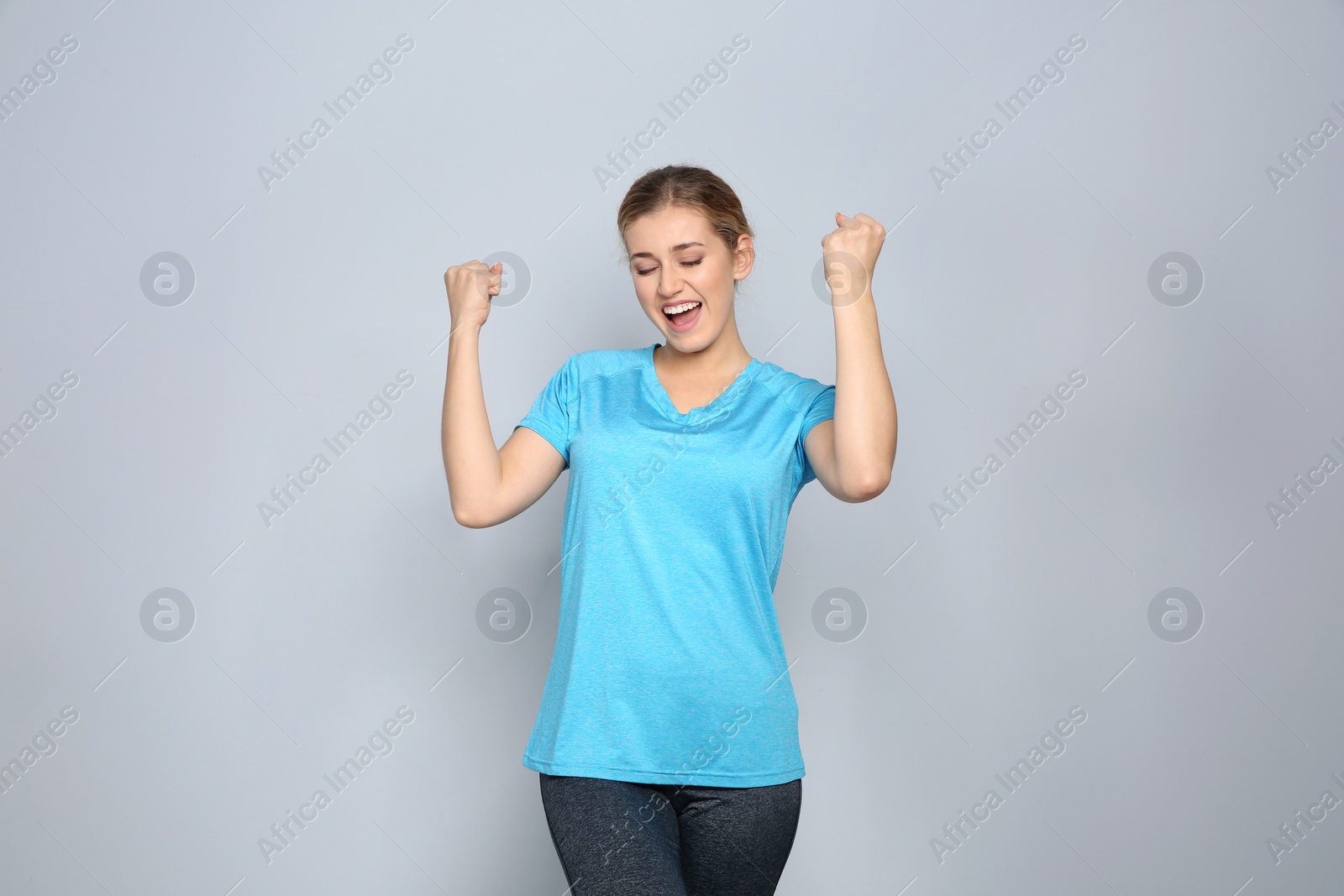 Photo of Happy young woman celebrating victory on color background