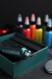 Photo of Tattoo equipment and machine in box on black table, closeup