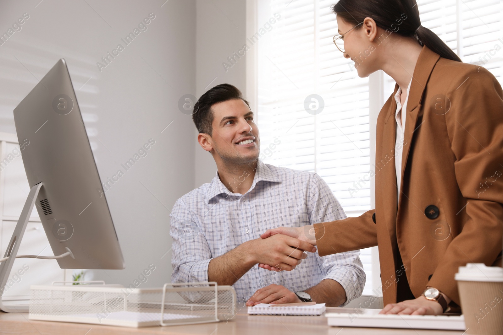 Photo of Employee shaking hands with intern in office