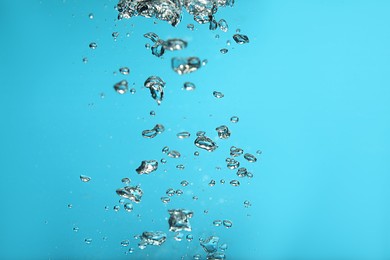 Air bubbles in water on light blue background