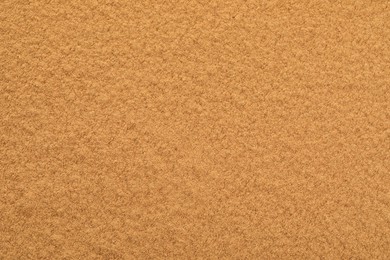 Dry aromatic cinnamon powder as background, top view