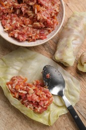 Photo of Preparing stuffed cabbage rolls on wooden board, flat lay