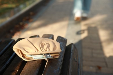 Woman lost her purse on wooden surface outdoors, selective focus