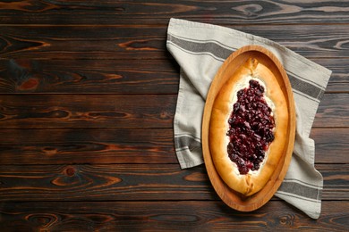 Photo of Delicious sweet cottage cheese pastry with cherry jam on wooden table, top view. Space for text