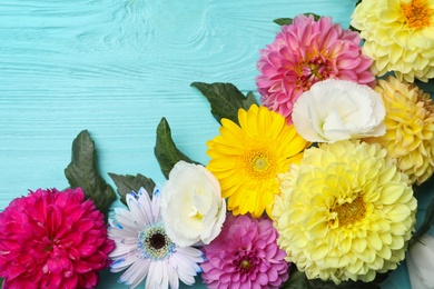 Flat lay composition with beautiful dahlia flowers on blue wooden background