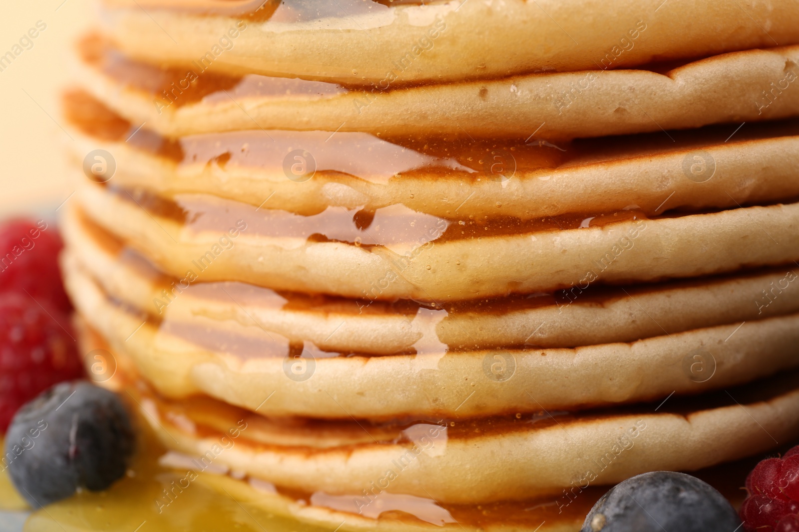 Photo of Stack of tasty pancakes with honey, closeup