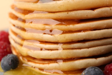 Photo of Stack of tasty pancakes with honey, closeup