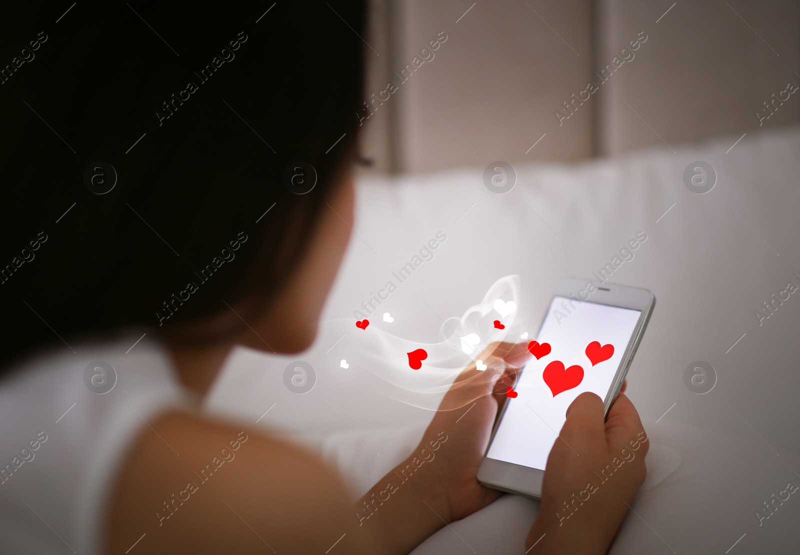 Image of Young woman visiting dating site via smartphone indoors