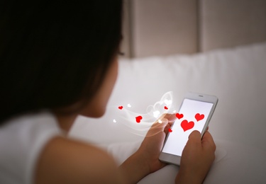 Young woman visiting dating site via smartphone indoors