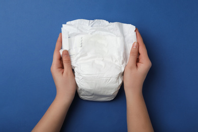 Photo of Woman with diaper on blue background, closeup