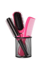 Photo of Hairbrushes and comb in holder on white background