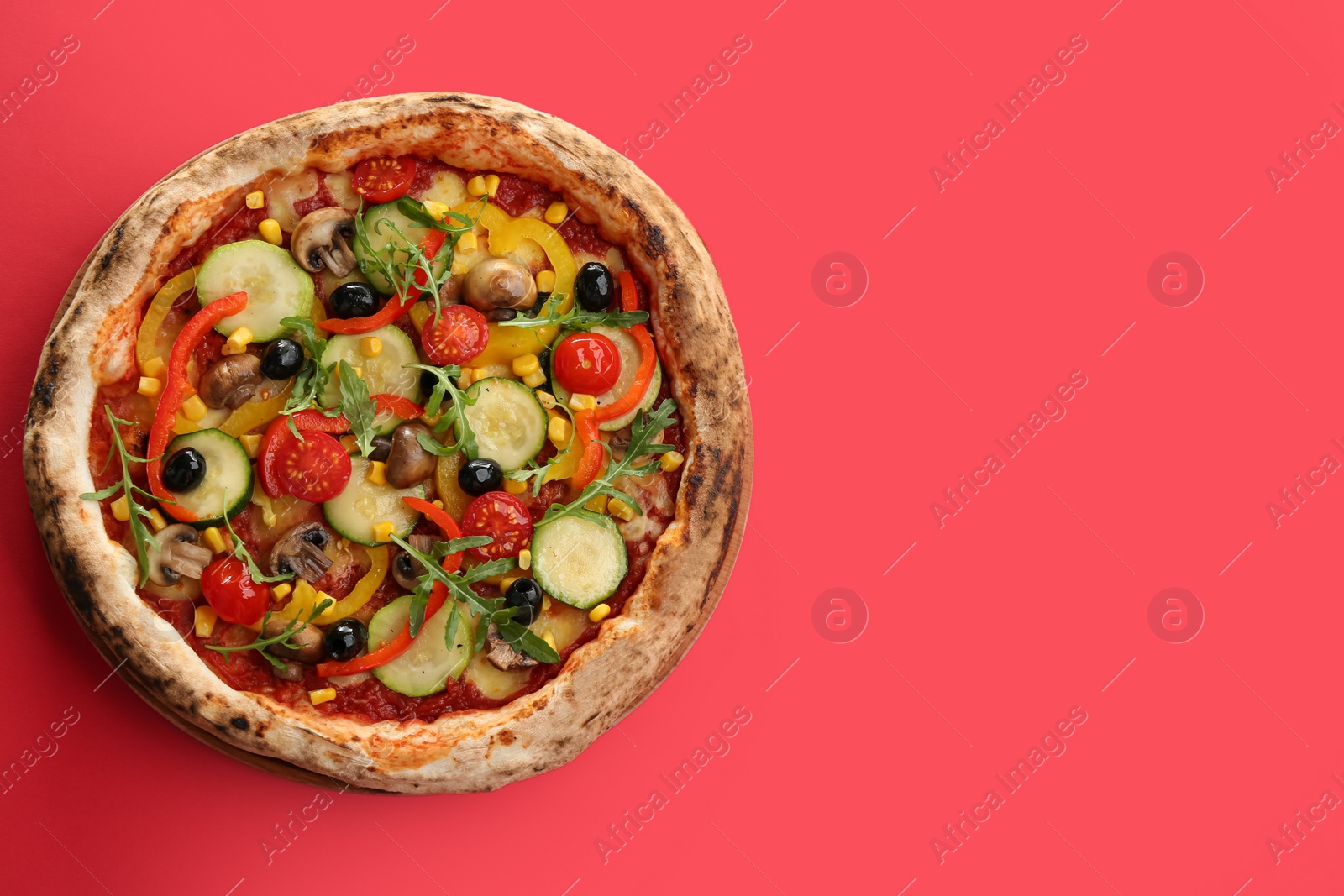 Photo of Delicious hot vegetable pizza on red background, top view. Space for text