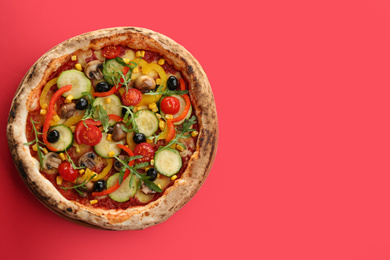 Photo of Delicious hot vegetable pizza on red background, top view. Space for text