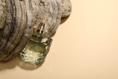 Luxury perfume in bottle and decorative element on beige background, top view. Space for text