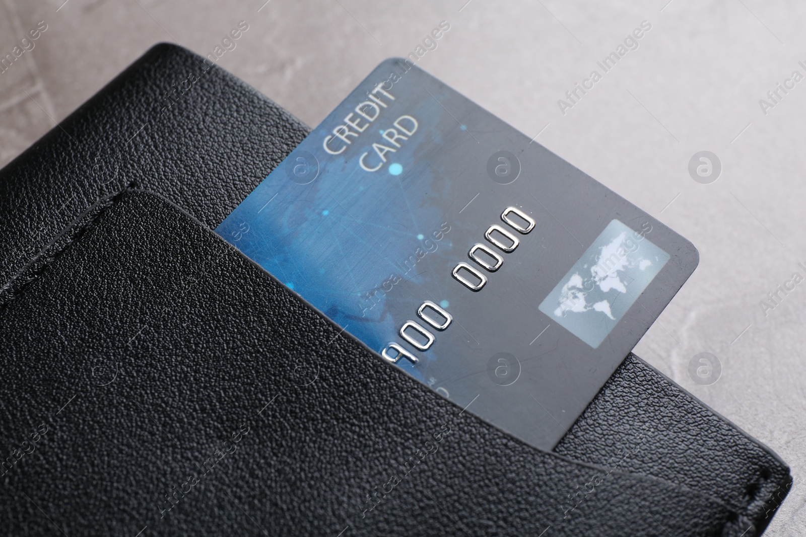 Photo of Credit card in leather wallet on grey textured table, closeup