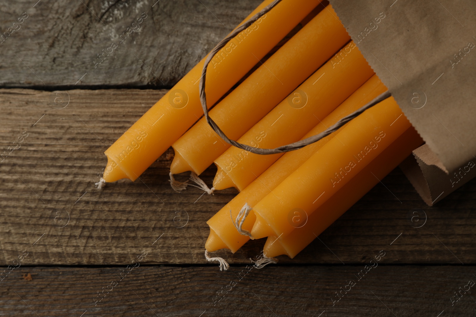 Photo of Many church wax candles on wooden table, flat lay