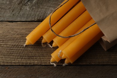 Many church wax candles on wooden table, flat lay