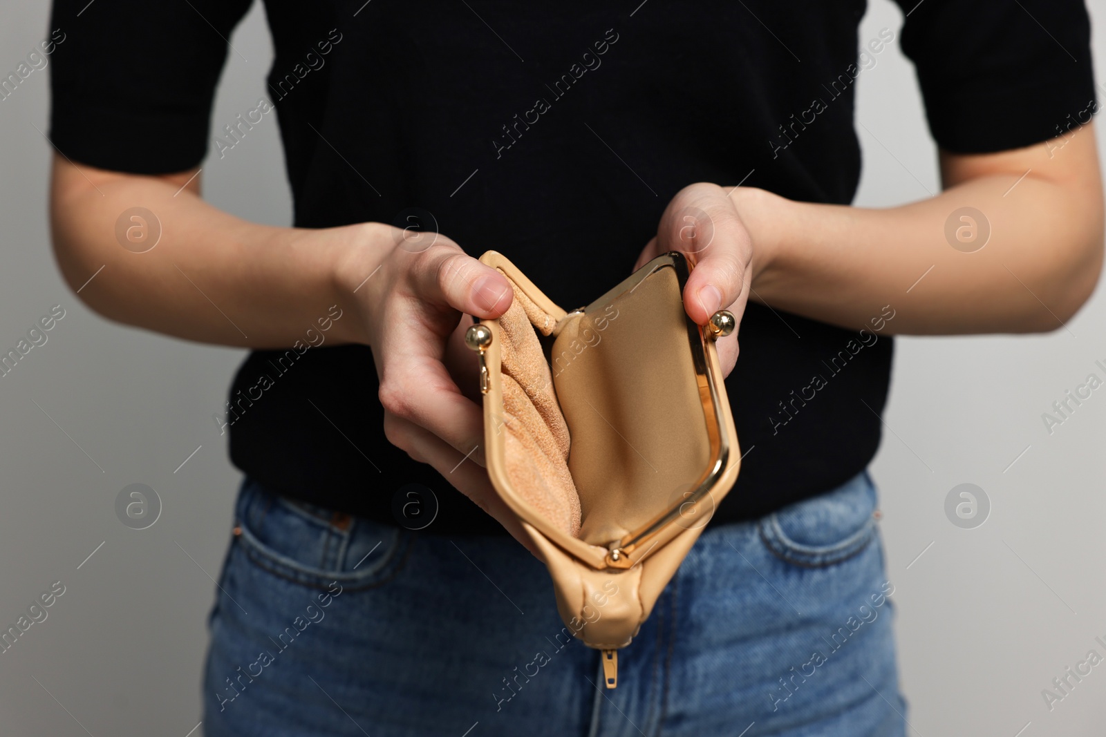 Photo of Woman with empty wallet on light grey background, closeup