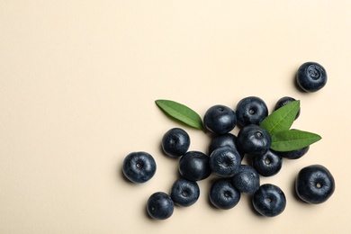 Photo of Fresh acai berries with leaves on beige background, flat lay. Space for text