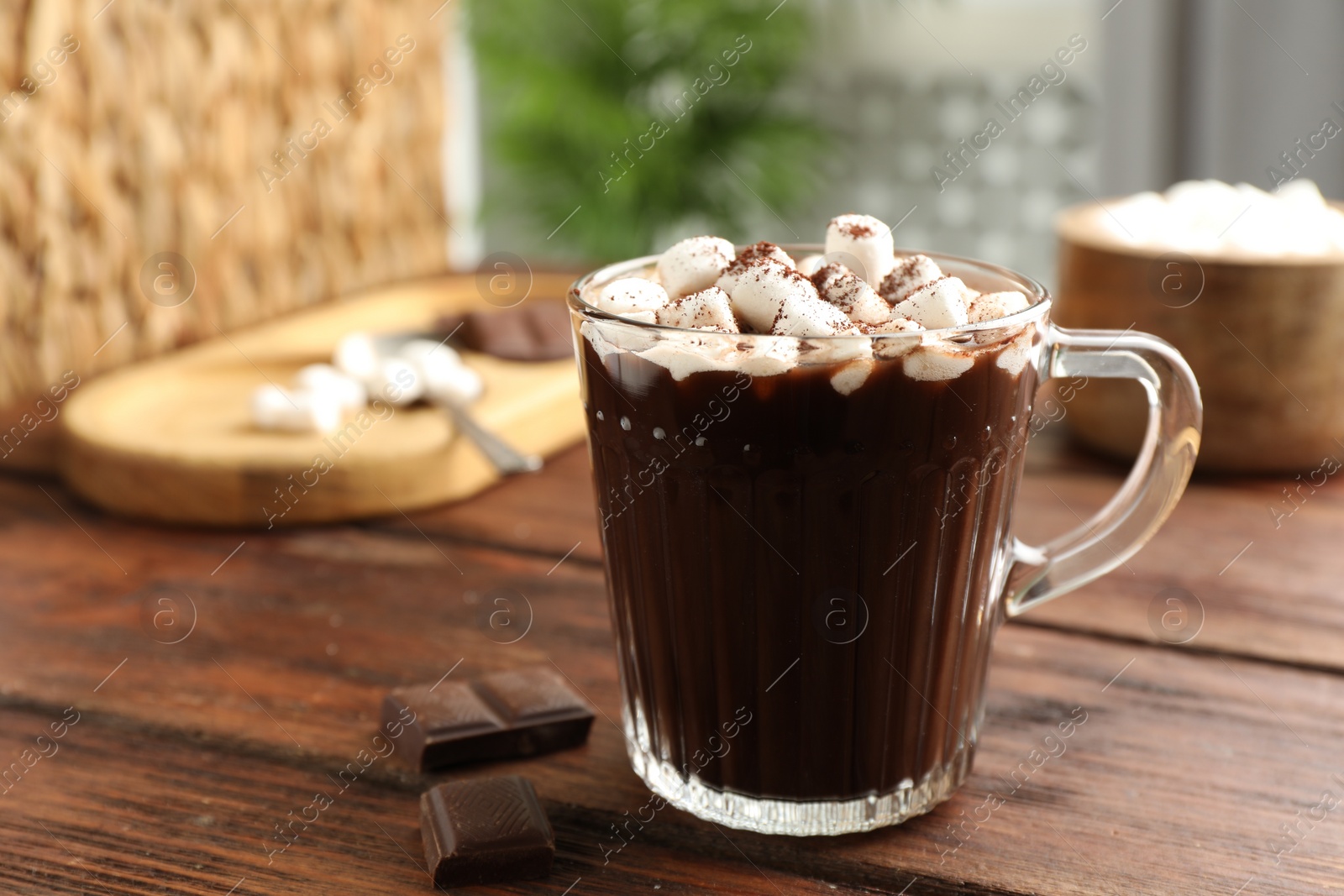 Photo of Cup of aromatic hot chocolate with marshmallows and cocoa powder on wooden table, closeup. Space for text