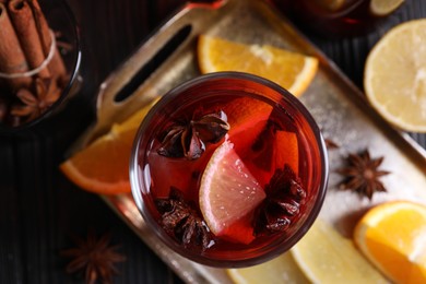 Photo of Glass of aromatic punch drink and ingredients on table, flat lay