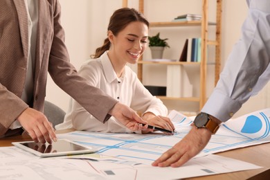 Professional cartographers working with cadastral map at table in office