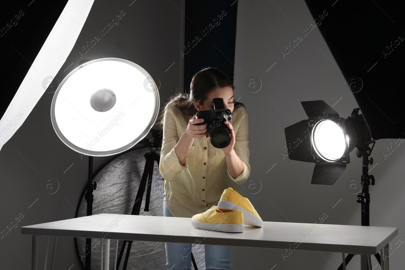 Photo of Professional photographer shooting stylish shoes in studio