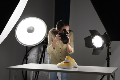 Professional photographer shooting stylish shoes in studio