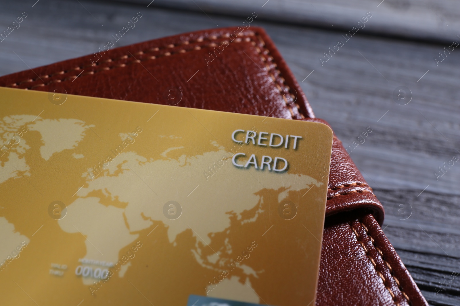 Photo of Credit card and leather wallet on grey table, closeup