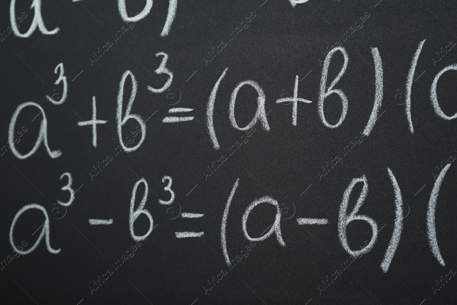 Photo of Many different math formulas written on chalkboard, closeup