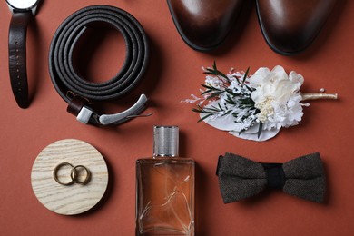 Photo of Wedding stuff. Flat lay composition with stylish boutonniere on brown background