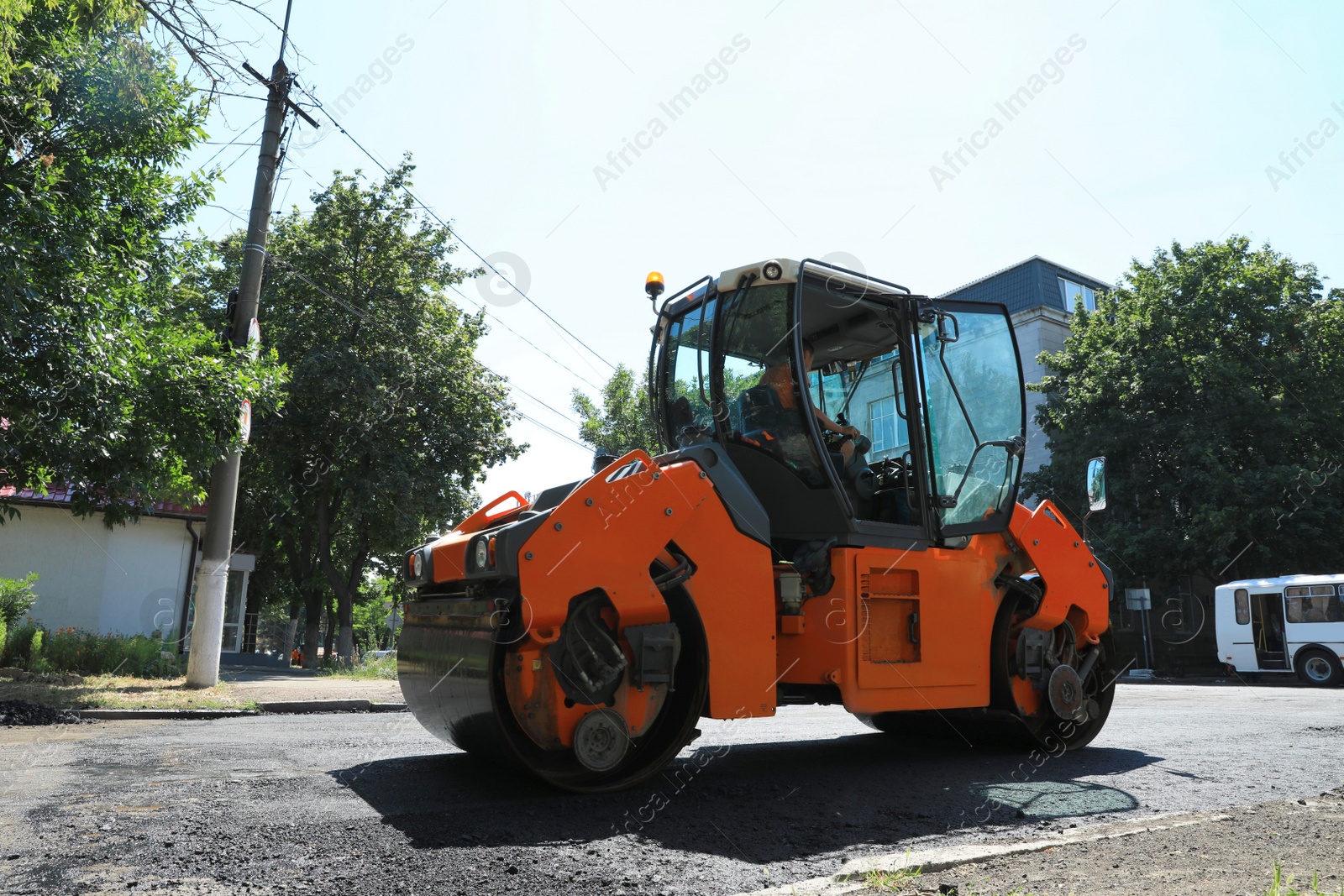 Photo of Roller working on city street. Road repairing