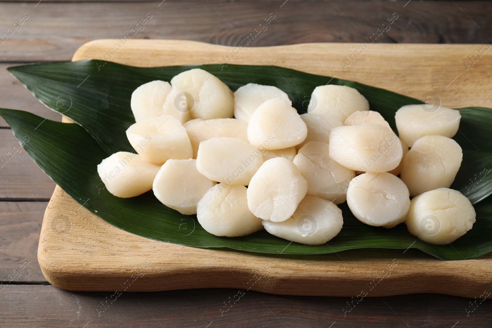 Photo of Fresh raw scallops on wooden table. Seafood