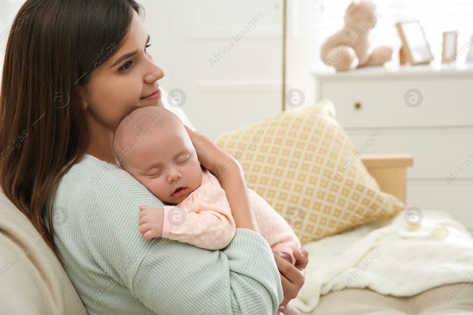 Photo of Mother holding her sleeping baby at home