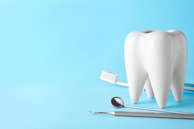 Photo of Tooth shaped holder and dentist tools on color background. Space for text